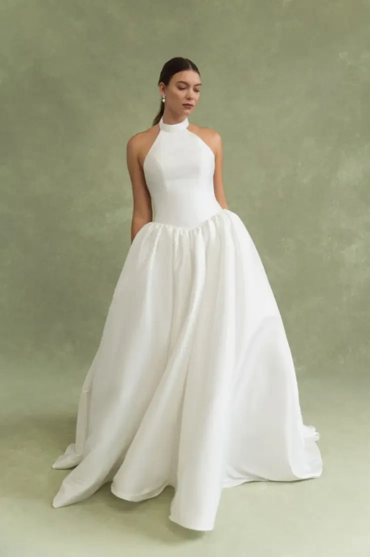 model is wearing a high neck sleeveless ball gown wedding dress