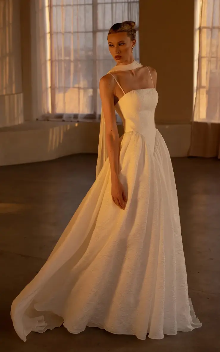 model is wearing a sleeveless spaghetti strap a-line bridal gown